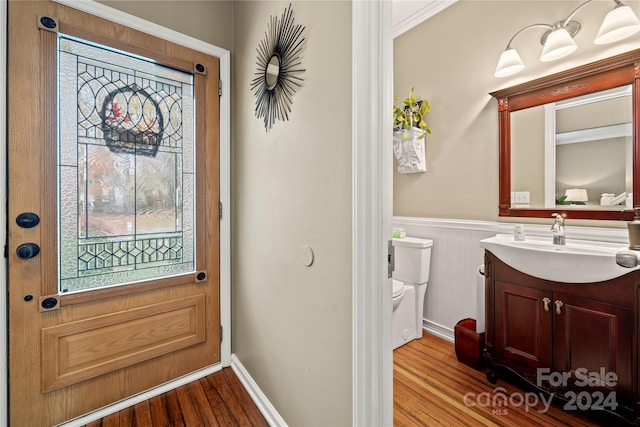 interior space with light wood-type flooring, crown molding, and sink