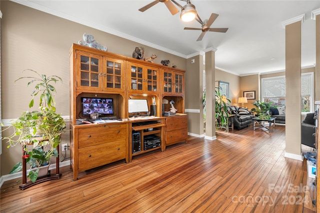 bar featuring decorative columns, crown molding, light hardwood / wood-style flooring, and ceiling fan