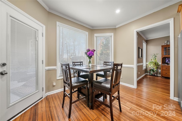 dining room featuring ornamental molding and light wood-type flooring