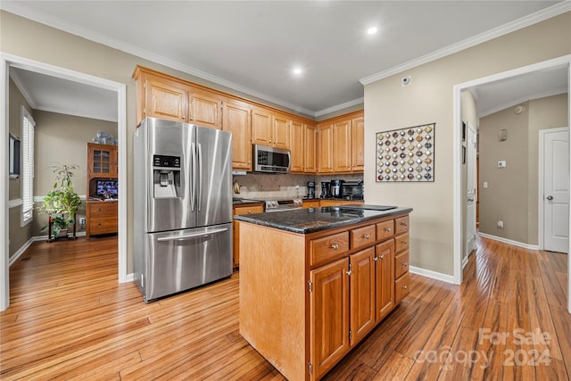 kitchen with dark stone counters, a kitchen island, light hardwood / wood-style floors, and appliances with stainless steel finishes