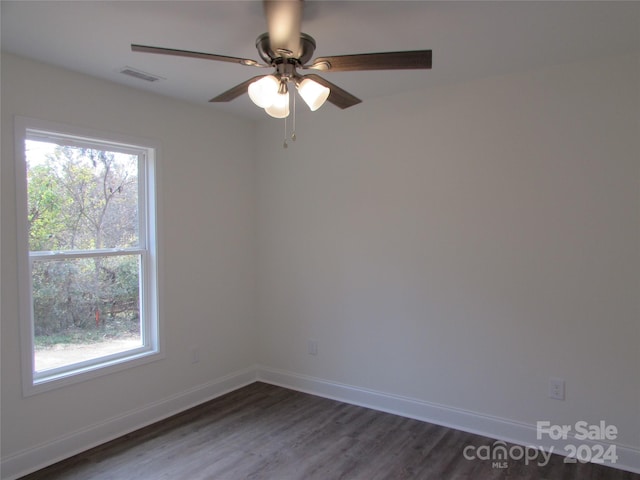 unfurnished room featuring dark hardwood / wood-style flooring, a wealth of natural light, and ceiling fan