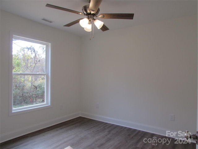 unfurnished room featuring plenty of natural light, ceiling fan, and dark wood-type flooring