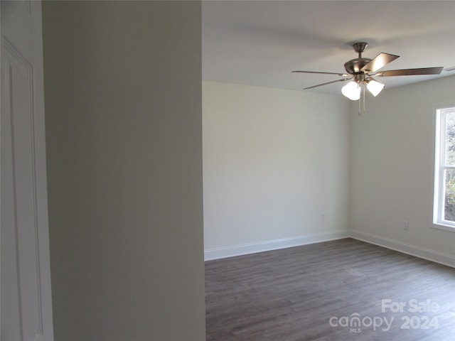 unfurnished room with ceiling fan and dark hardwood / wood-style flooring