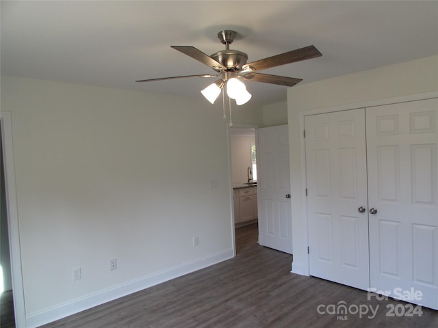 unfurnished bedroom featuring dark hardwood / wood-style flooring, a closet, ceiling fan, and sink