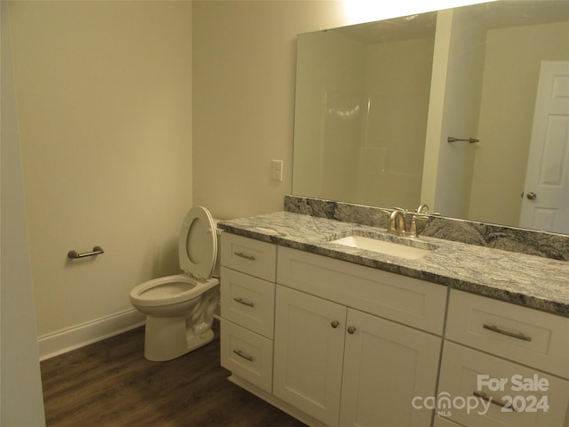 bathroom with hardwood / wood-style floors, vanity, and toilet