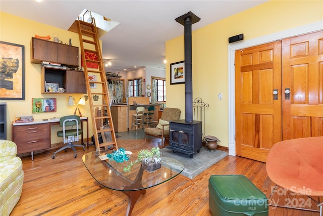 living room with a wood stove and light wood-type flooring