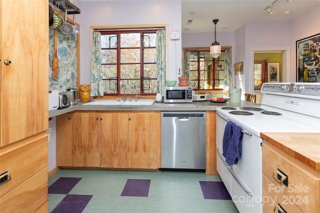 kitchen with sink, stainless steel appliances, and decorative light fixtures