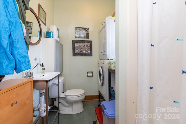 bathroom with toilet and stacked washing maching and dryer