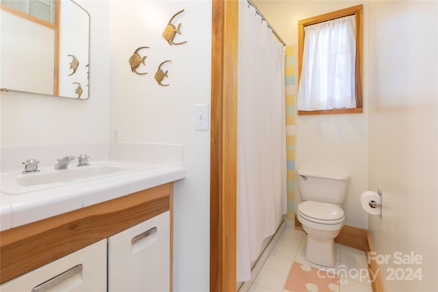 bathroom featuring tile patterned flooring, vanity, and toilet