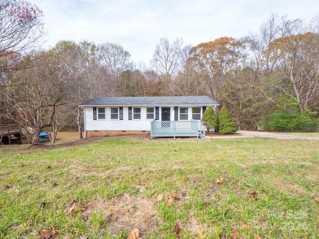 ranch-style home featuring a front yard and a wooden deck