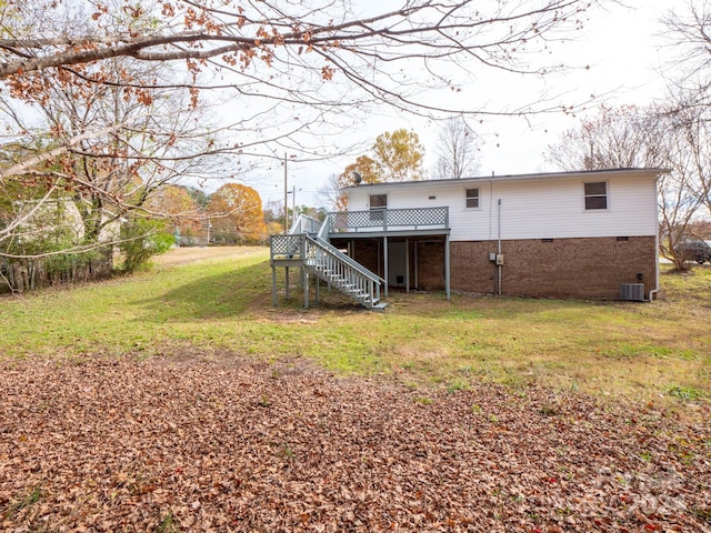 rear view of property featuring a deck, a yard, and central air condition unit