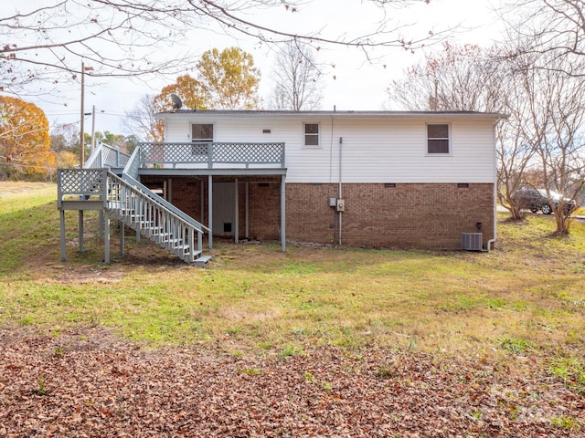 rear view of house featuring a lawn, a deck, and central AC