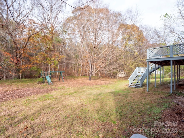 view of yard featuring a playground and a wooden deck