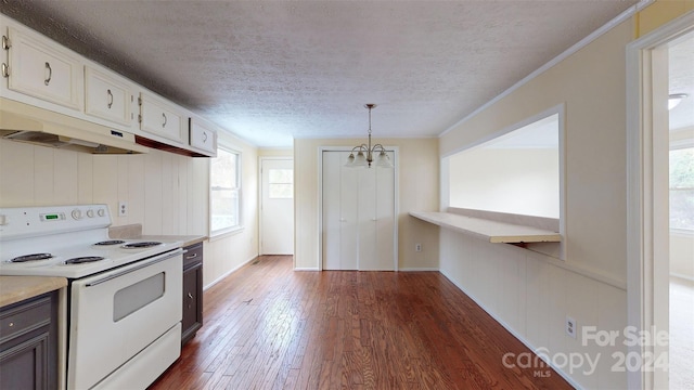 kitchen with white electric stove, hanging light fixtures, dark hardwood / wood-style floors, a notable chandelier, and white cabinetry