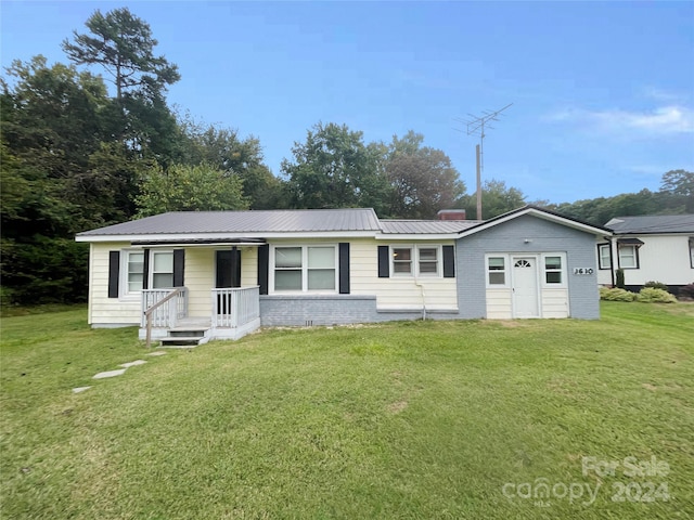 ranch-style home with covered porch and a front yard