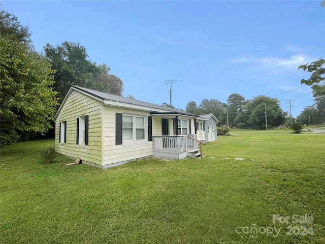 view of side of home featuring a porch and a yard