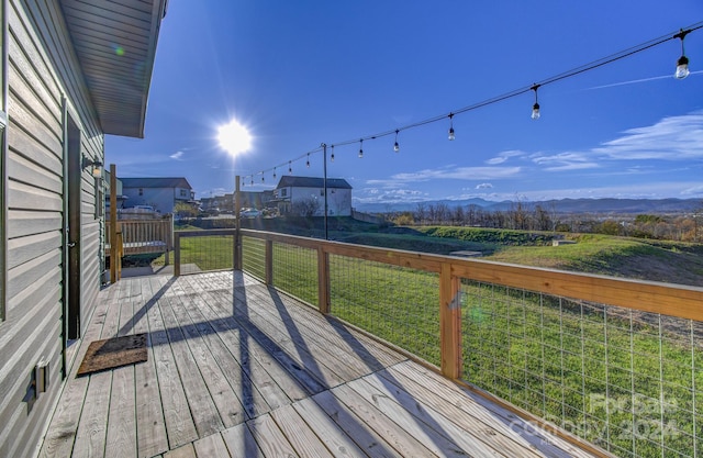 wooden terrace with a mountain view and a yard