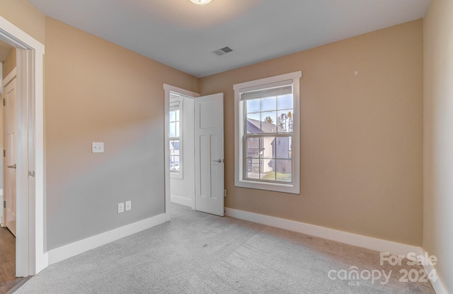 unfurnished bedroom featuring light carpet