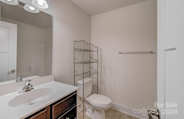 bathroom with tile patterned flooring, vanity, and toilet