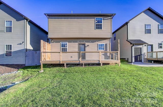 back of property with a lawn and a wooden deck