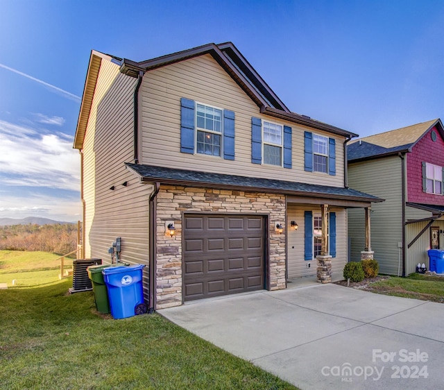 view of front of house featuring central AC unit, a garage, and a front lawn