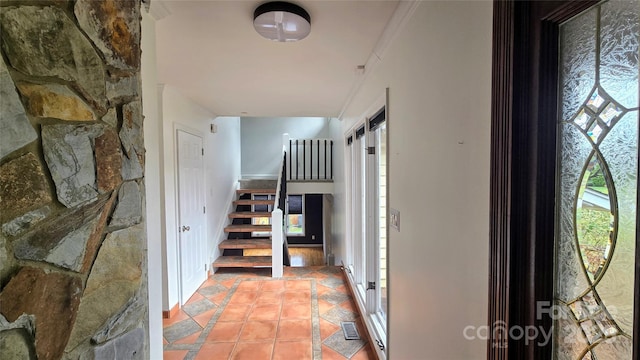 staircase featuring crown molding and tile patterned flooring