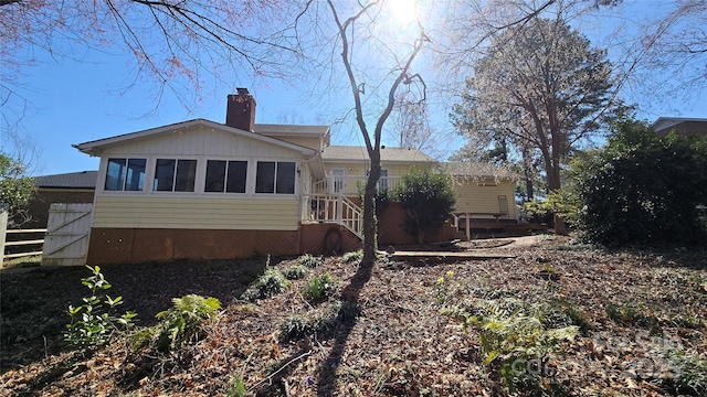 back of property with a chimney and fence