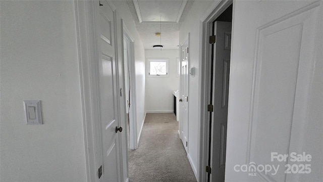 corridor with carpet flooring, attic access, and baseboards