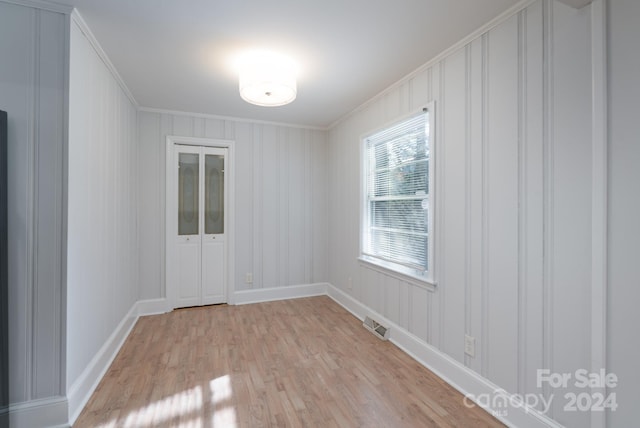 unfurnished room featuring light hardwood / wood-style floors and ornamental molding