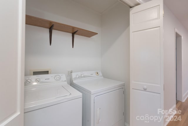 washroom with washing machine and dryer, light wood-type flooring, and crown molding