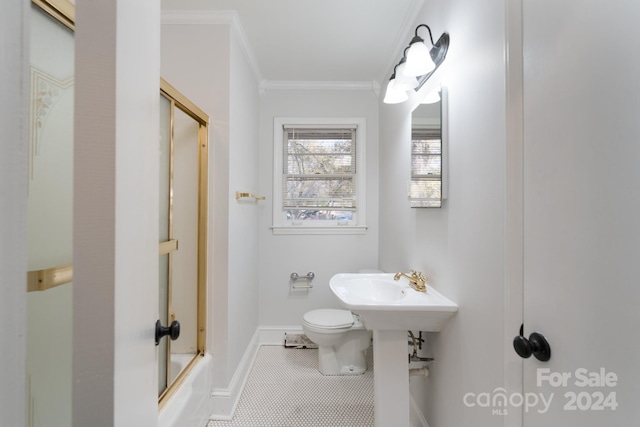 bathroom with tile patterned floors, toilet, combined bath / shower with glass door, and crown molding