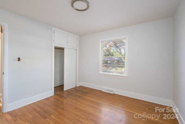 unfurnished bedroom with a closet and light hardwood / wood-style flooring