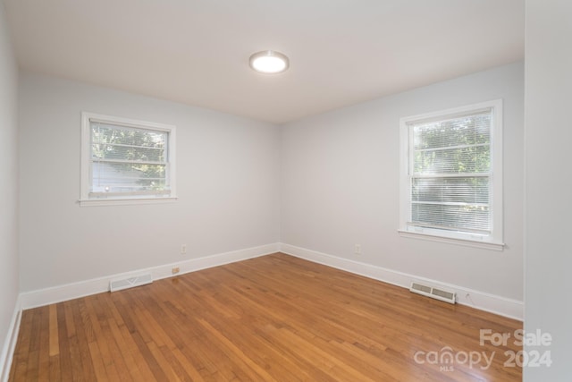 empty room featuring plenty of natural light and wood-type flooring