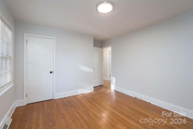 empty room with plenty of natural light and hardwood / wood-style flooring