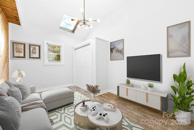 living room with hardwood / wood-style flooring, vaulted ceiling with skylight, and a chandelier