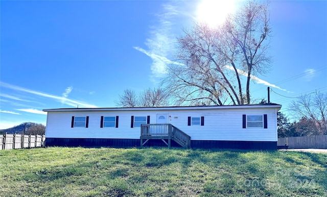 manufactured / mobile home featuring a front lawn and a wooden deck