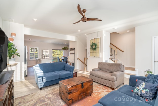 living room featuring ceiling fan, sink, and light hardwood / wood-style floors