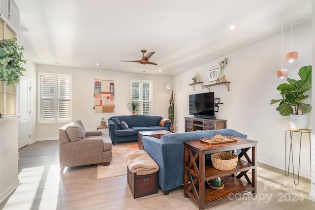 living room featuring ceiling fan, plenty of natural light, and light wood-type flooring