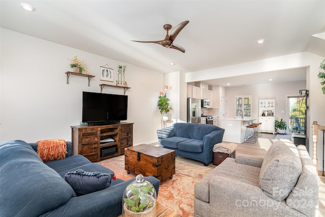 living room featuring ceiling fan and light hardwood / wood-style floors