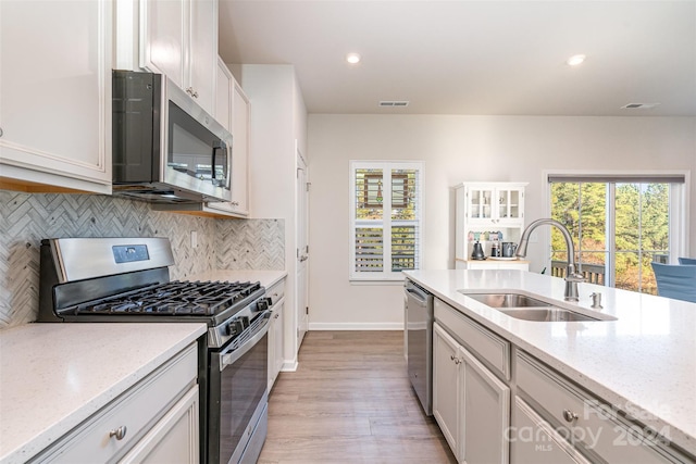 kitchen with sink, light wood-type flooring, plenty of natural light, and appliances with stainless steel finishes