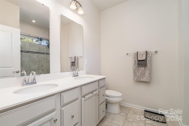 bathroom with tile patterned flooring, vanity, toilet, and a shower with shower door