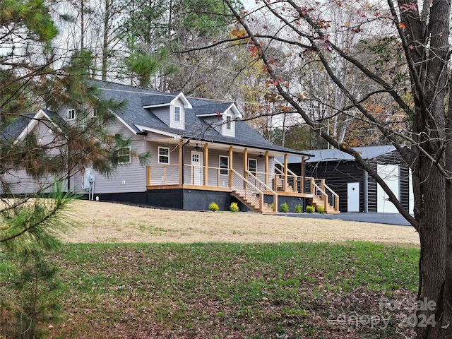 view of front of house featuring a porch, a garage, and a front lawn