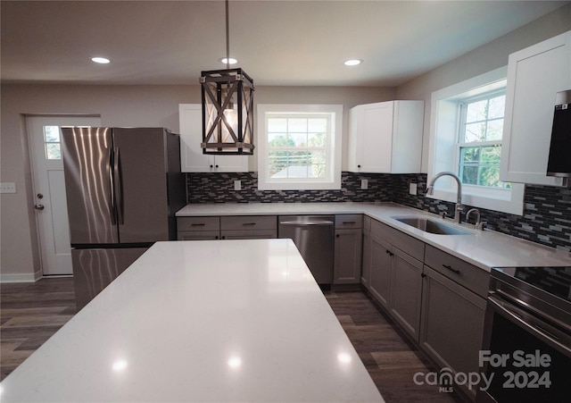 kitchen featuring appliances with stainless steel finishes, dark hardwood / wood-style floors, a healthy amount of sunlight, and sink