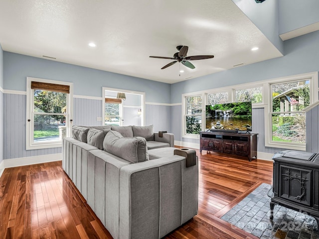 268 Firefly Cv, Lake Lure, NC 28746 - living area featuring a wood stove, dark wood-style flooring, a ceiling fan, a wainscoted wall, and recessed lighting