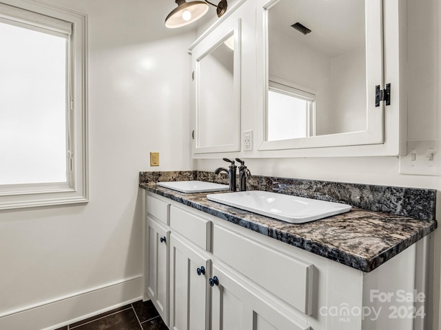 bathroom with a wealth of natural light, tile patterned flooring, and vanity