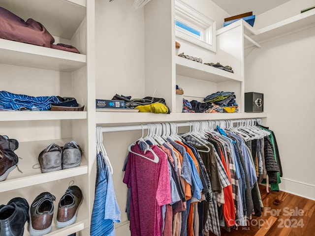 walk in closet with dark wood-type flooring