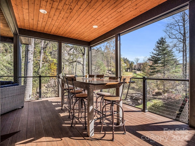 sunroom / solarium featuring a wealth of natural light and wooden ceiling