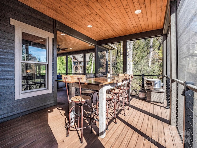 sunroom featuring ceiling fan and wooden ceiling