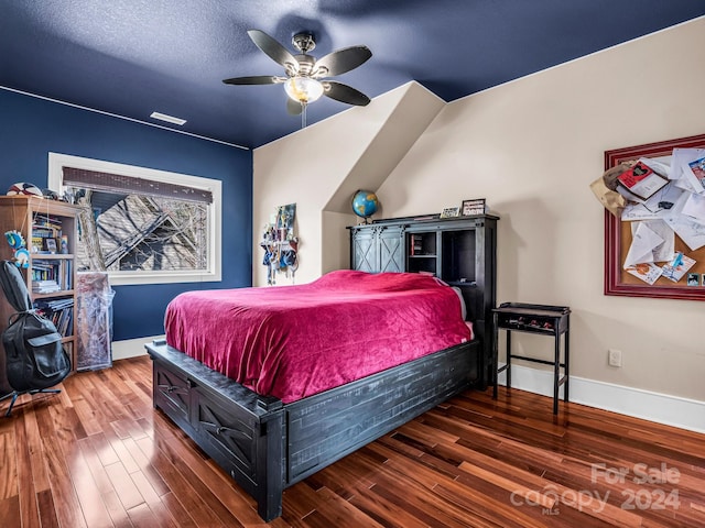 bedroom with hardwood / wood-style floors, ceiling fan, and a textured ceiling