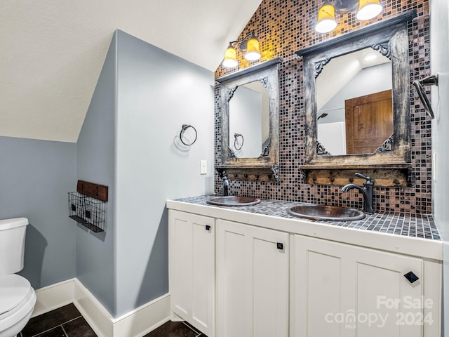 bathroom featuring tile patterned floors, decorative backsplash, toilet, and vaulted ceiling